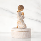 Right side: cream oval resin box, 3-D figure in prayer pose atop lid, in cream dress carved with birds and flowers