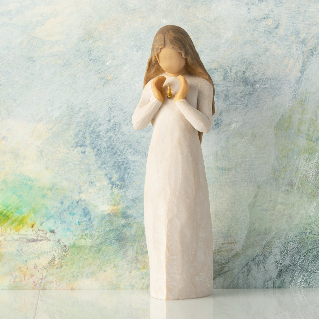 Front view, standing female figure in cream dress, hands surrounding small gold-leaf flame on chest, muted blue painted background