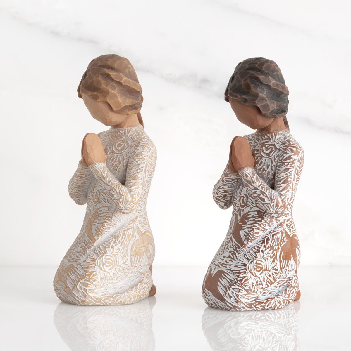 Lighter & Darker skin Kneeling figures, hands in position of prayer or meditation in cream dress carved with icons of nature, lighter and darker skin versions