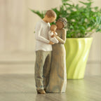 Front view of standing couple, woman has darker skin and hair; man has lighter skin and hair, holding a baby between them. Potted plant in background.
