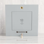 Back of dove gray wood frame with keyhole hanger and built-in kickstand
