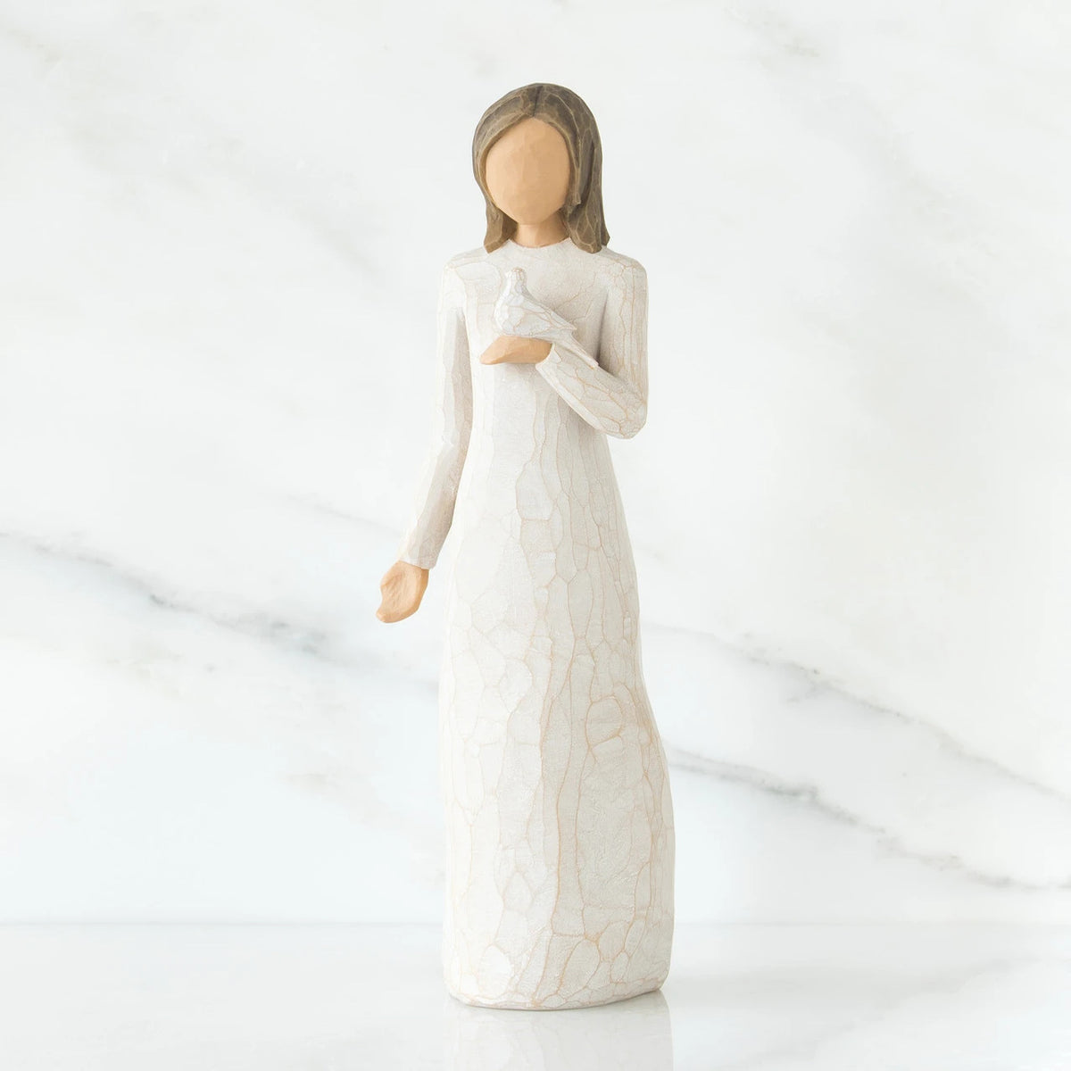 Woman figurine with brown hair in white dress holding white dove