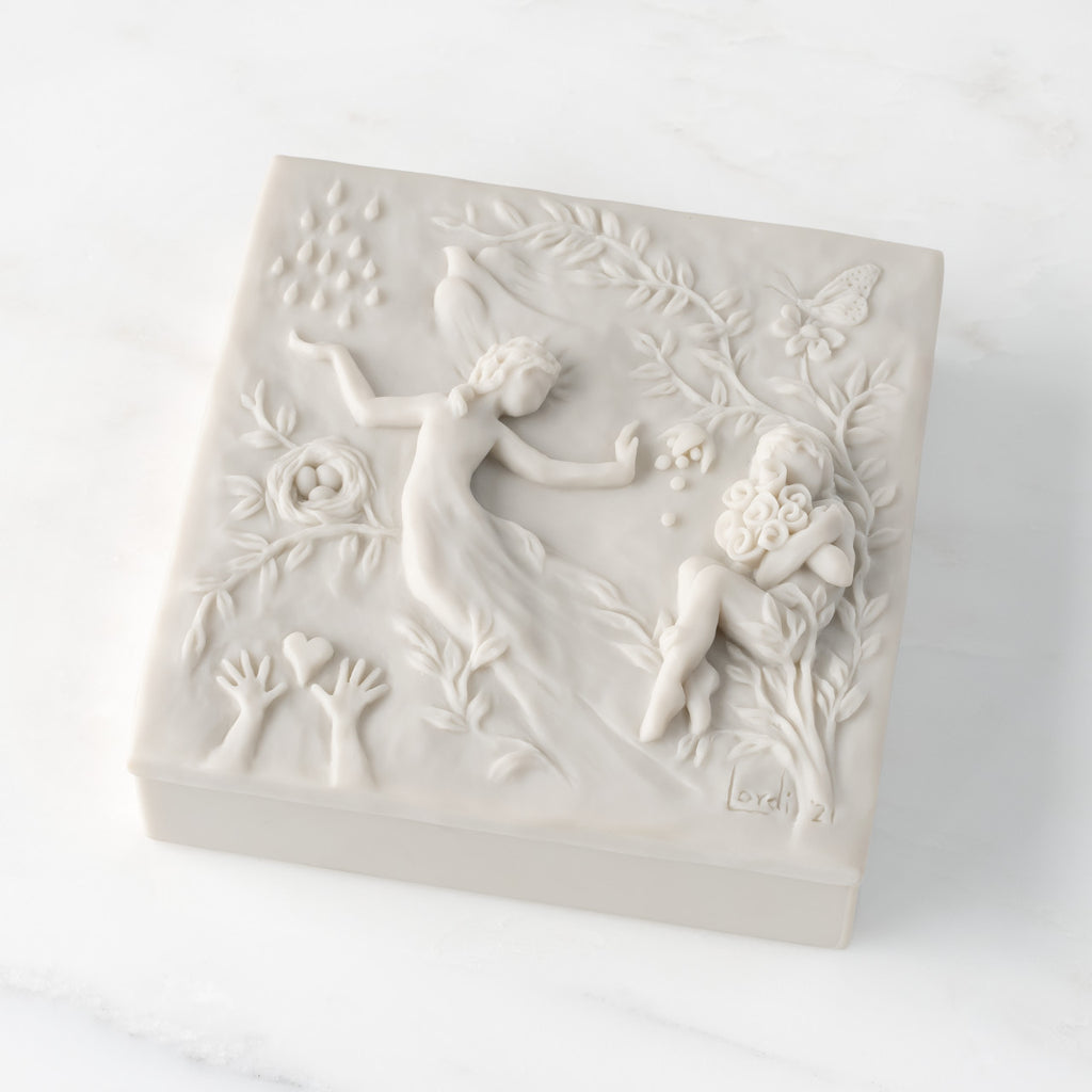 Closed white resin square box; lid carved with figural and organic imagery