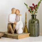 Willow Tree Anniversary, 6”h hand-painted resin figure of older couple sitting on bench holding hands, both in neutral clothing, on table with mementos