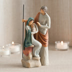 Man figurine standing next to mother figurine in blue holding baby