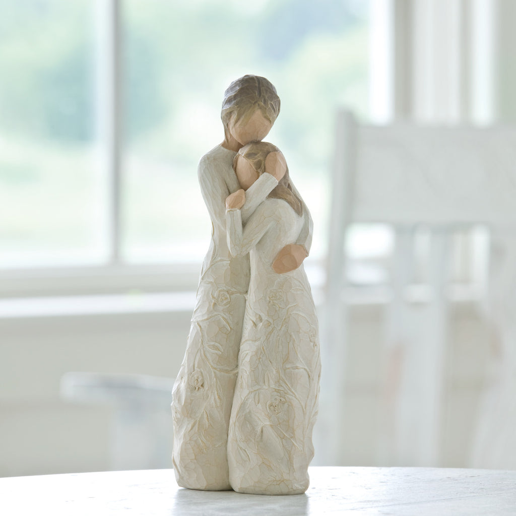 Willow Tree Close to me, 8"h hand-painted standing resin figure of woman embracing tween girl, both in cream dresses carved with intertwined vines and leaves, on shelf near window