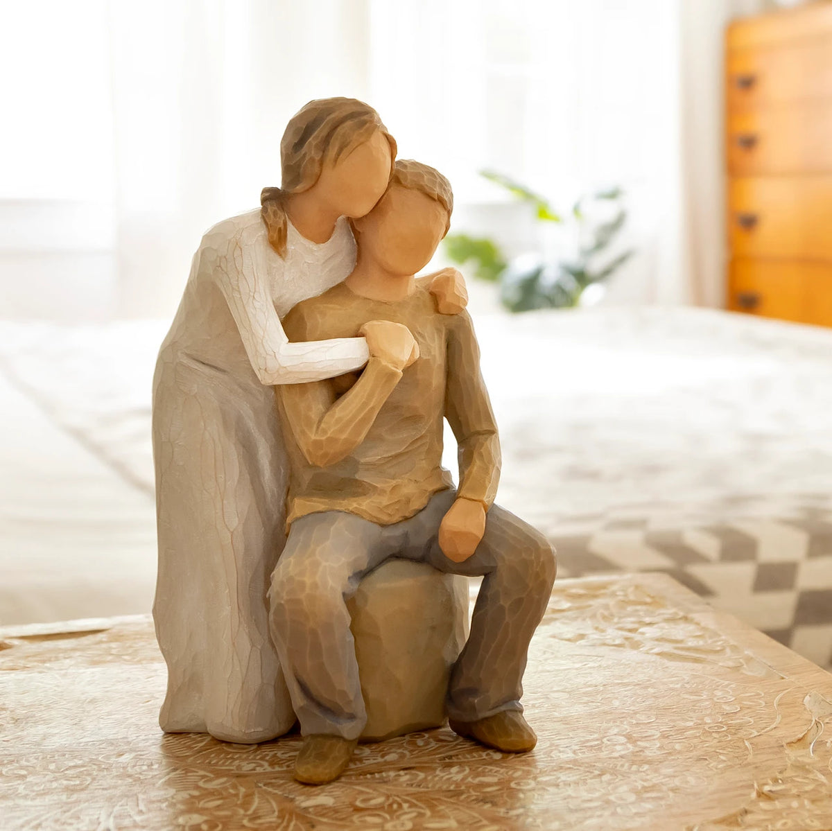 Willow Tree You and Me, 7”h hand-painted resin figure of couple; seated man, woman standing behind with arms around neck, both in neutral clothes, on bedroom table